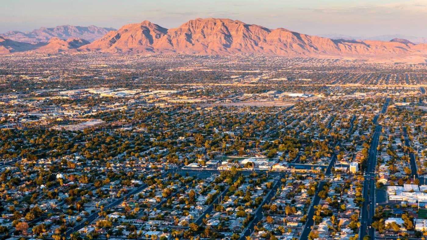 Aerial view of sprawling Phoenix cityscape with desert mountains at sunset